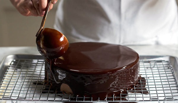 Chef Jacques Torres glazing cake with chocolate ganache